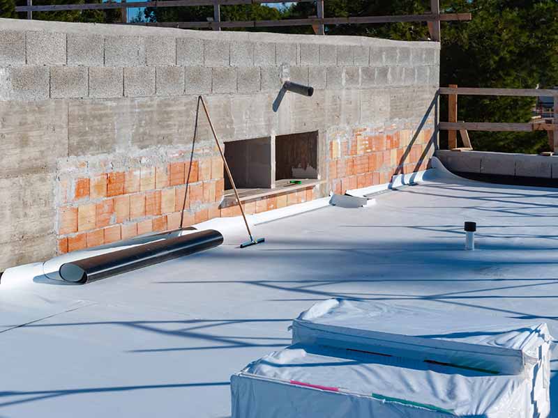 Small commercial roof in the process of getting a new single-ply, white membrane roof system installed